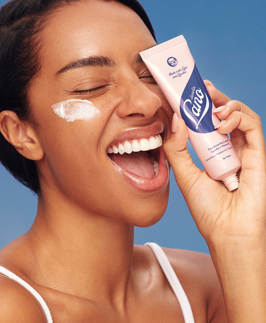 Model holding lanolips face base tube in her hand.