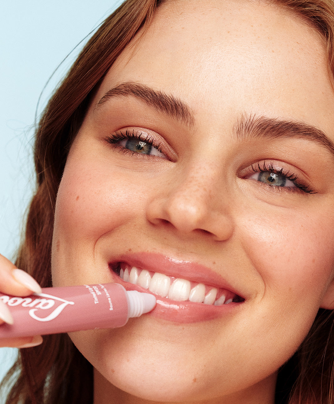 Model holding 101 ointment multipurpose superbalm tubes in various flavours strawberry, green apple, original, coconutter, peach and watermelon.