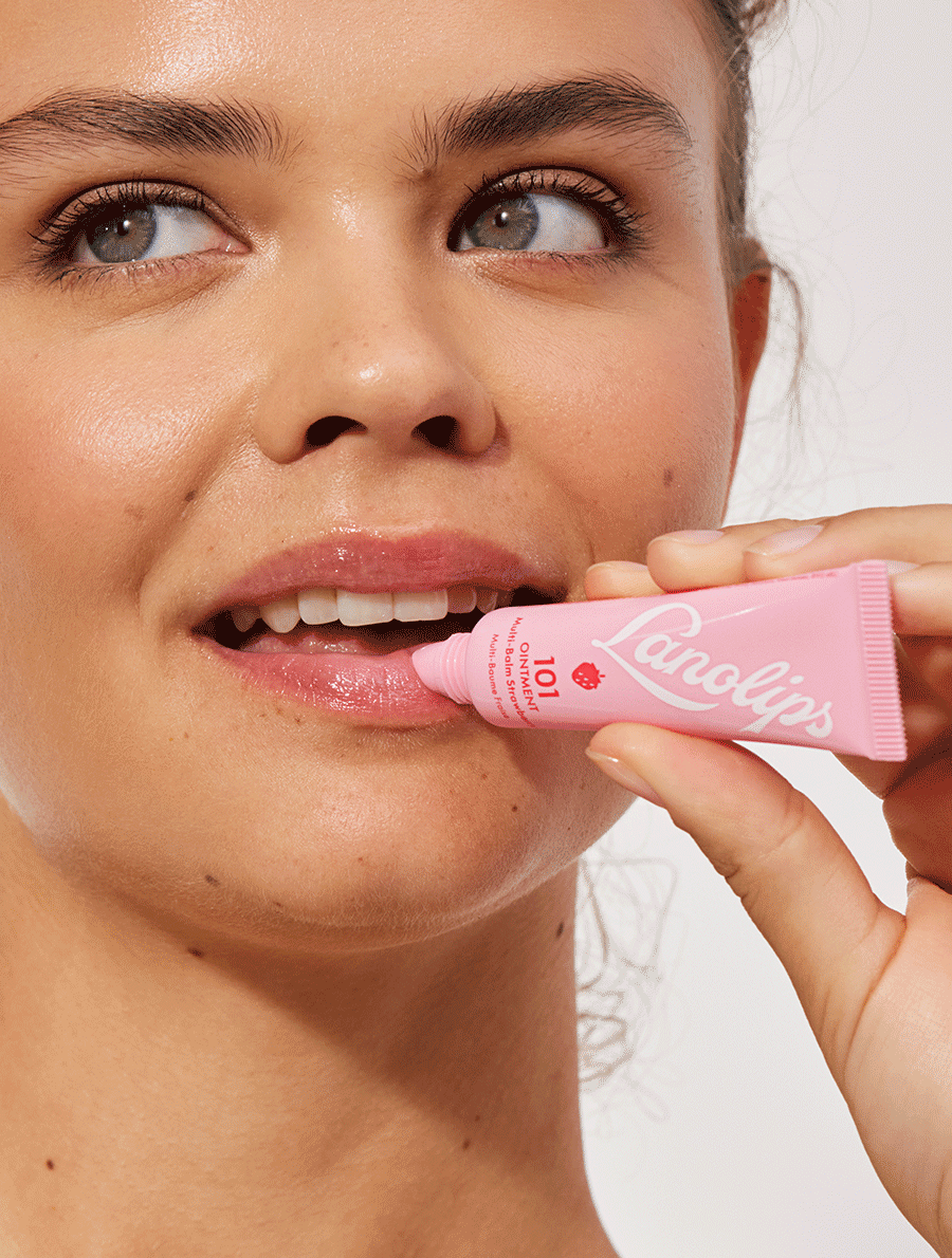 Model applying Lanolips 101 Ointment Multi Balm in Strawberry.