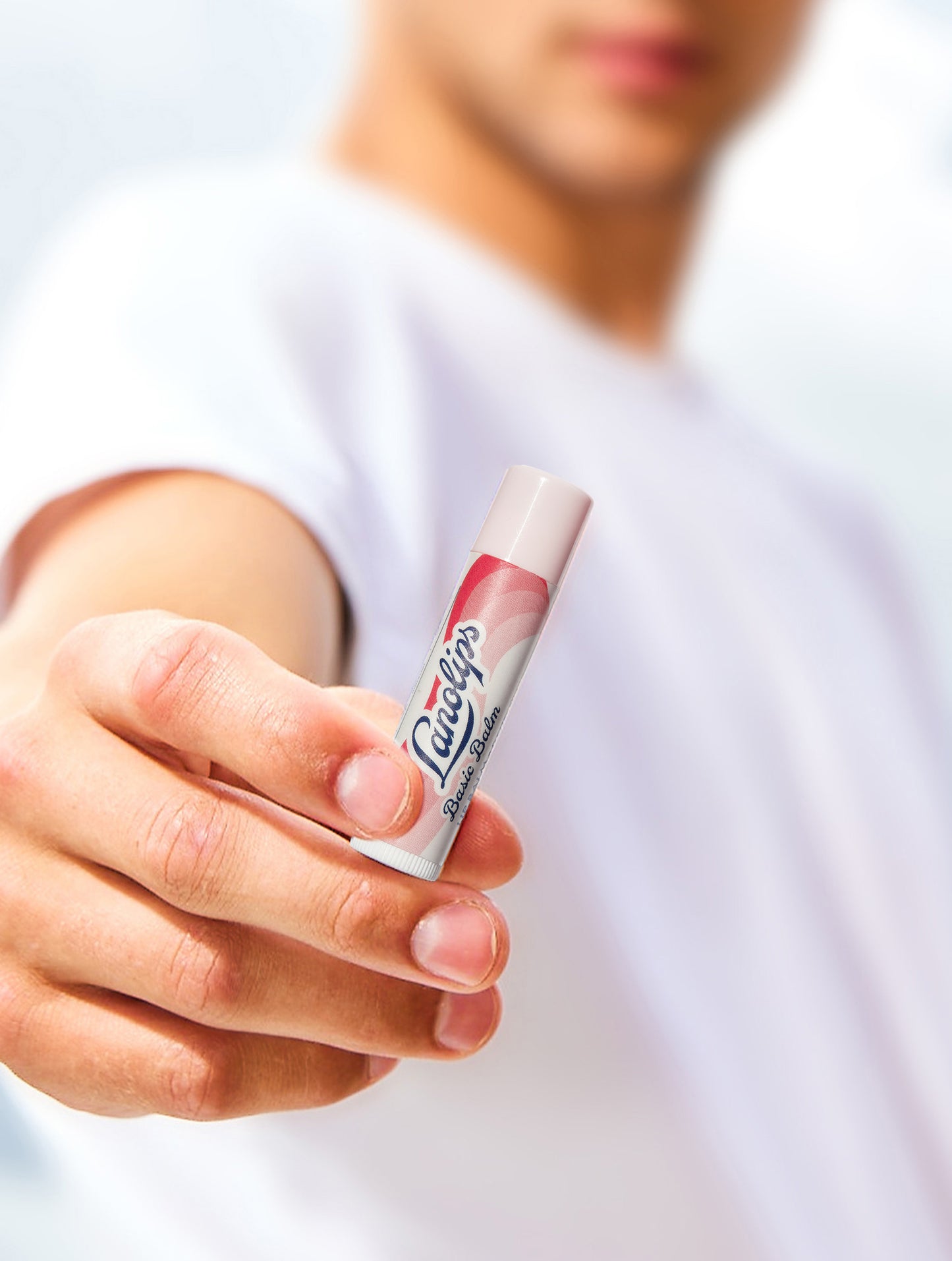 Lifestyle shot of a person holding a Lanolips Basic Balm Strawberry.