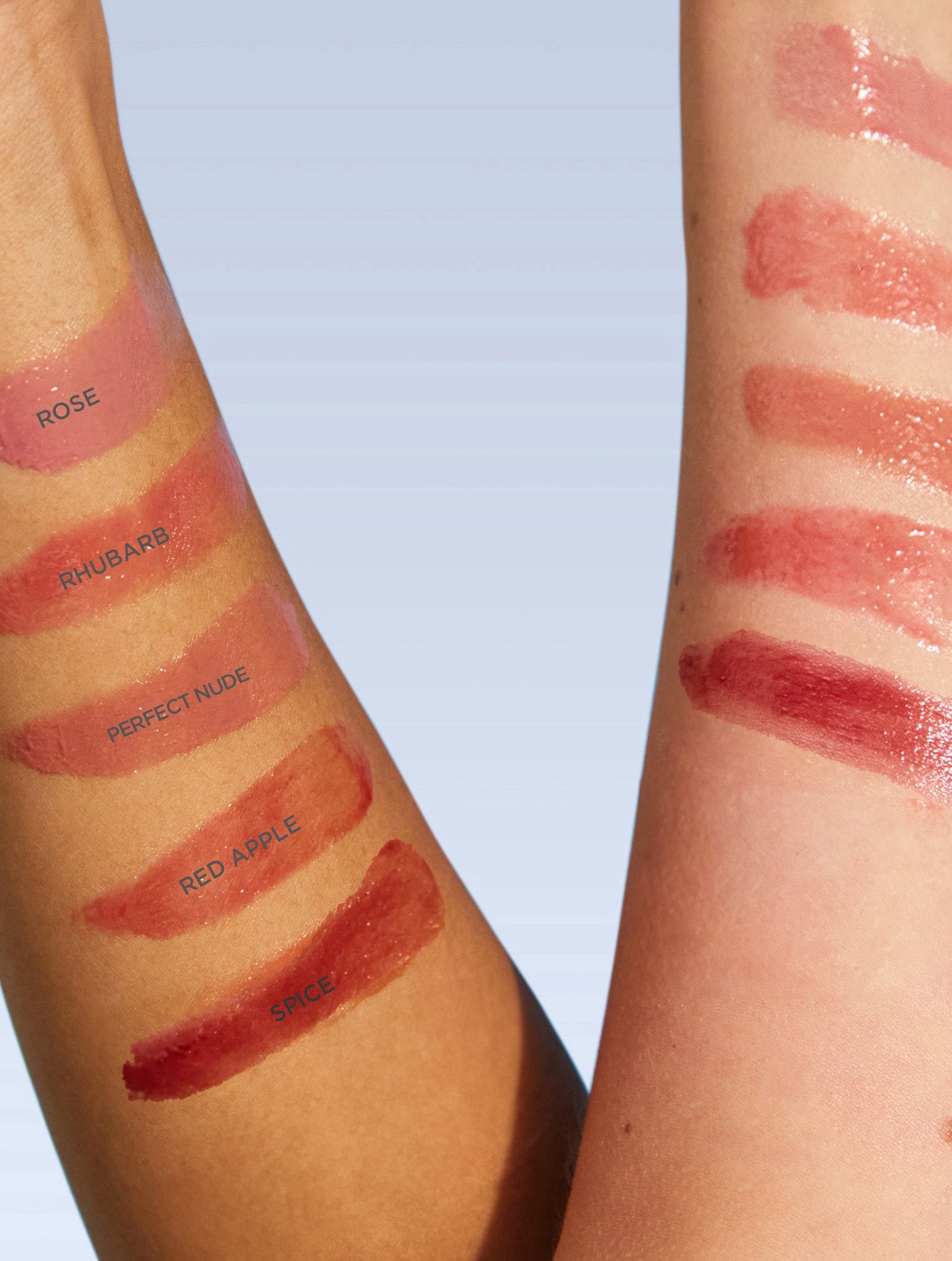 Swatches of Lanolips Tinted Lip Balm SPF30 range in shades Rose, Rhubarb, Perfect Nude, Red Apple and Spice are spread across a white background, showcasing their sheer, glossy finish. This lanolin-rich lip moisturiser provides deep hydration while delivering a sheer colour tint for a natural, healthy glow. The lightweight, non-sticky formula enhances lips with a dewy, tinted shine, making it the perfect everyday essential.