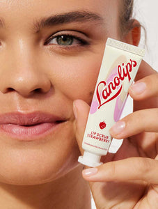 Model holding Lanolips Lip Scrub Strawberry. Our lip scrub is a conditioning lip scrub that is 100% natural.