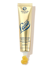 Lanolips Golden Dry Skin Miracle Salve in a metallic gold squeezable tube with a white cap. The packaging features the Lano logo in deep blue lettering, along with ‘Made with Love and Lanolin’ inscribed at the top. A small amount of the rich, golden balm is shown oozing from the tube, emphasising its ultra-hydrating, multi-purpose formula designed to deeply nourish and repair very dry skin, hands, and rough patches.