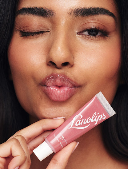 Model wearing and winking Lanolips Tinted Lip Balm SPF 30 in Rhubarb