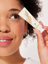 Model holding Lanolips Lip Scrub Coconutter. Our lip scrub is a conditioning lip scrub that is 100% natural.
