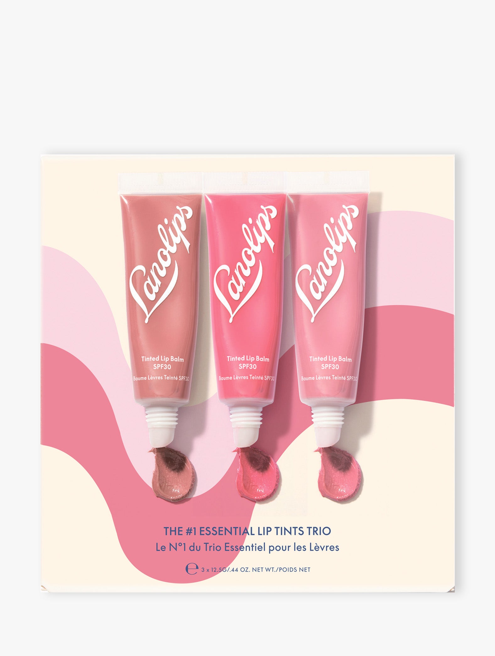 Product shot of the Lanolips The #1 Essentials Lip Tints Trio packaging on beige background. The set contains our three best-selling shades: Perfect Nude, Rhubarb and Rose. 
